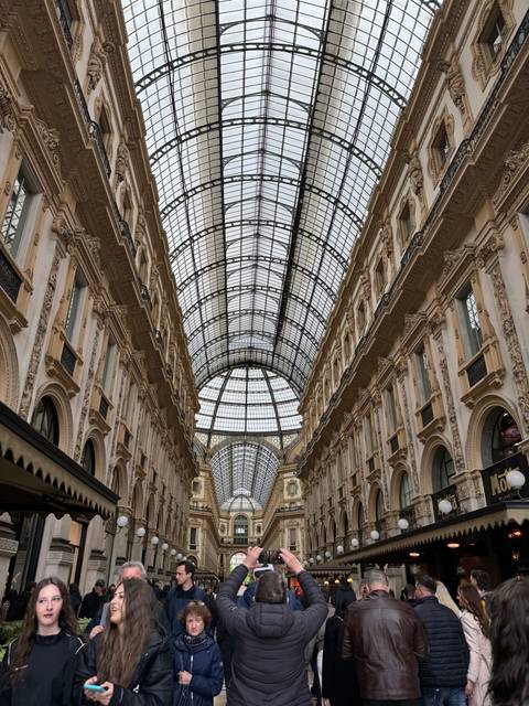 Interior of a grand shopping arcade with glass ceiling.