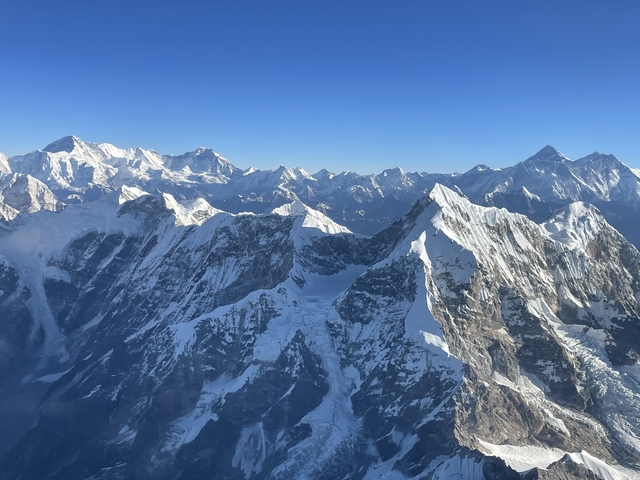 Impressive view of a range of snow-capped mountains under a clear sky.