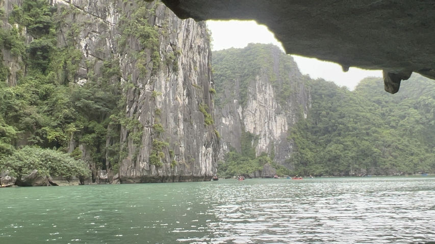       View from under a rocky cave opening to a bay.
  