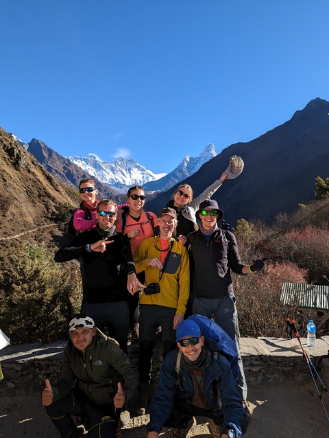 Group of happy hikers posing in a mountainous landscape.