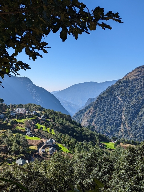       Mountainous valley with small village visible at the bottom.
  