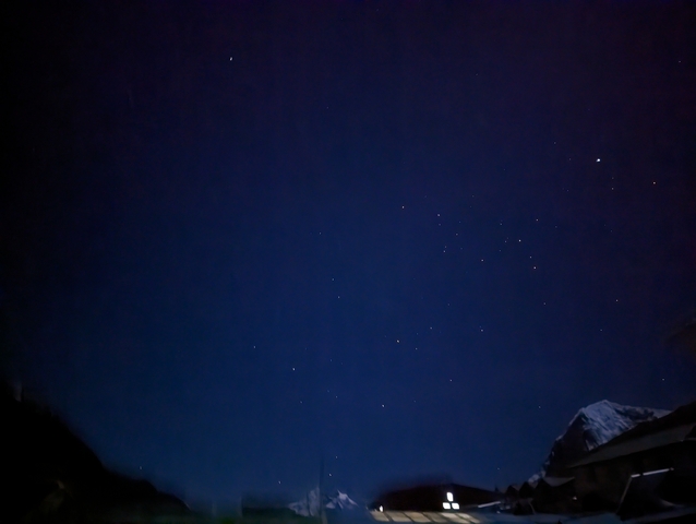       Night sky with visible stars and a mountain peak silhouette.
  