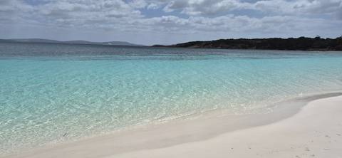 Clear turquoise water and white sandy beach.