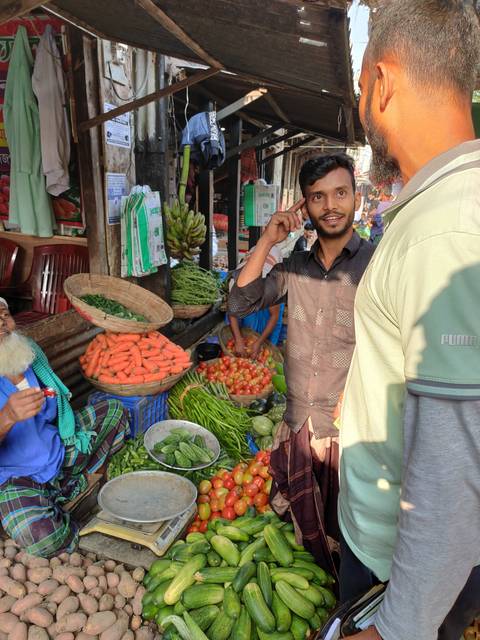 Market scene with people and a variety of vegetables on display.