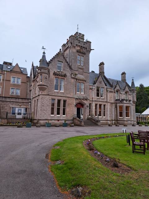       Stone manor with green lawn.
  