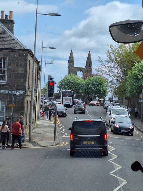 Busy street with traffic and historic stone gate.