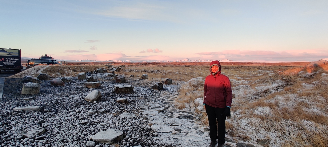       Person standing on a frosty landscape with a pink sky
  