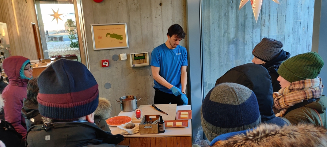       Person preparing food in front of a group
  
