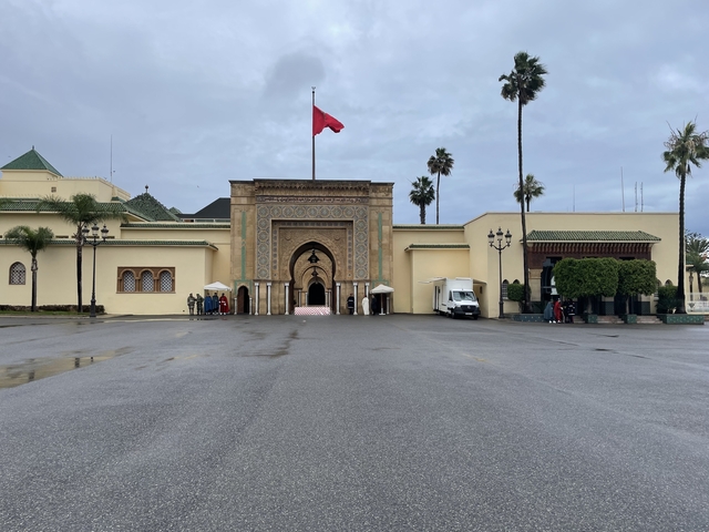       Moroccan palace complex with a flag on a clear day
  