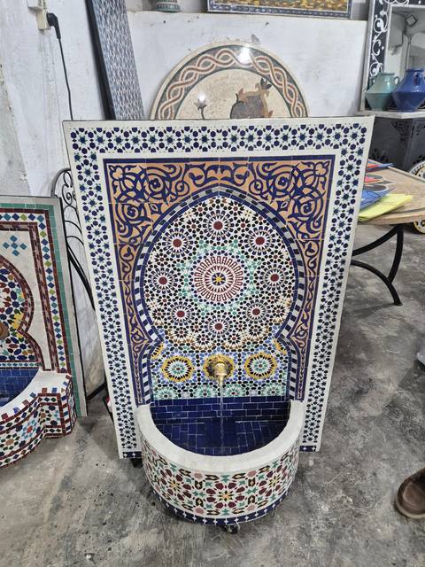 Ornate mosaic fountain with geometric and floral designs.