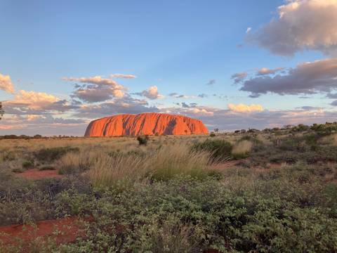 Uluru during sunset with clouds.