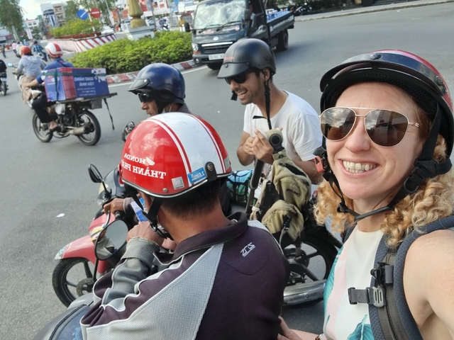 Group of people on motorcycles in a busy city street.