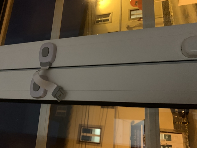 Photo of a window hinge in dim lighting.