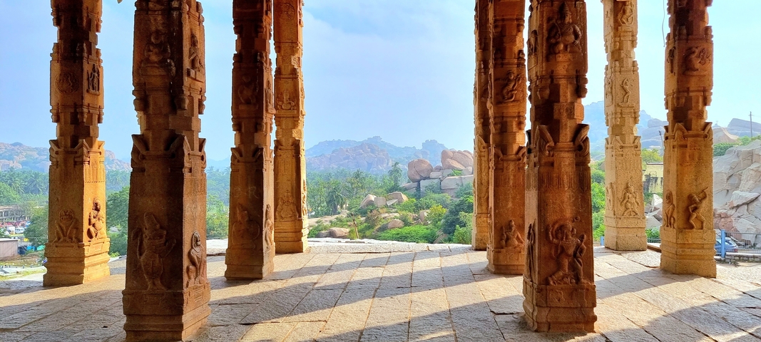       View of rock pillars with a scenic landscape background.
  