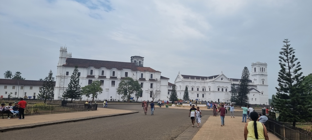       Large historic church-like structure with people walking around.
  