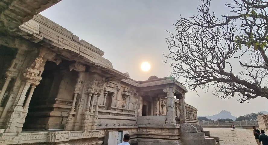       Temple architecture with sunlight and a distant mountain view.
  