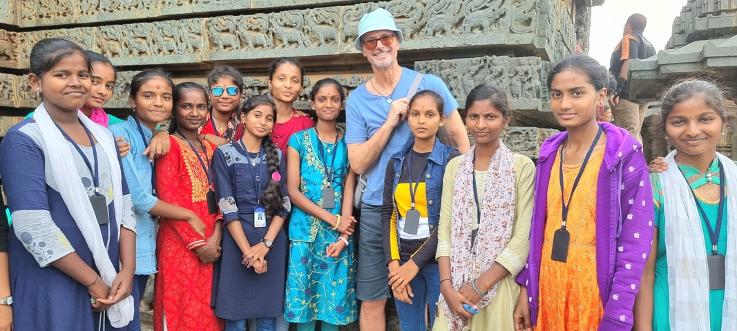       Group of people posing in front of a temple sculpture.
  
