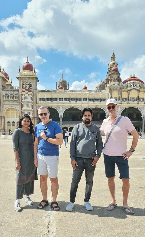      Group of people standing outside Mysore Palace.
  