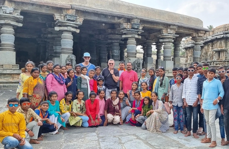       Large group of people posing in front of an ancient temple.
  