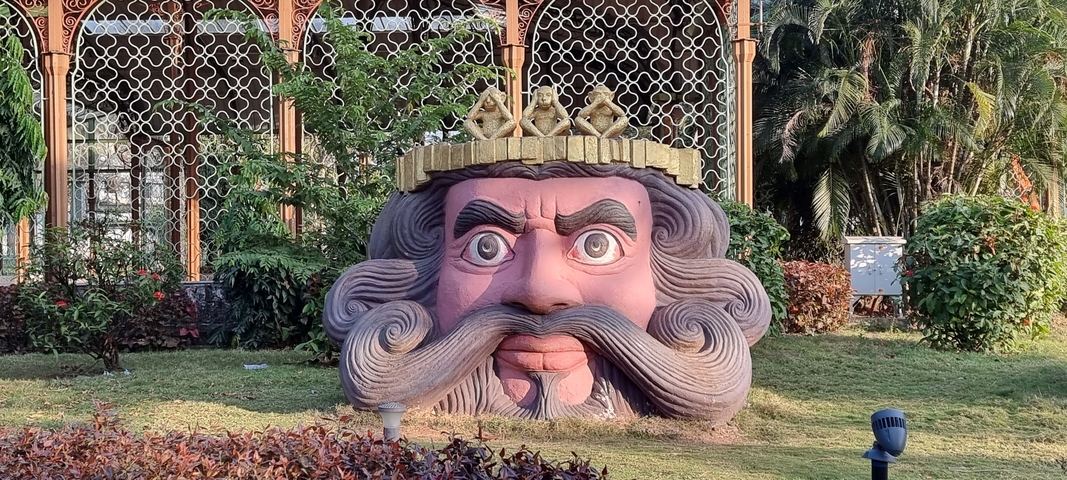       Large sculpture of a face with a mustache and crown.
  