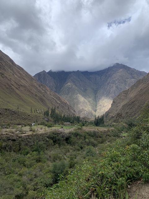       Valley view with mountains and cloudy sky.
  