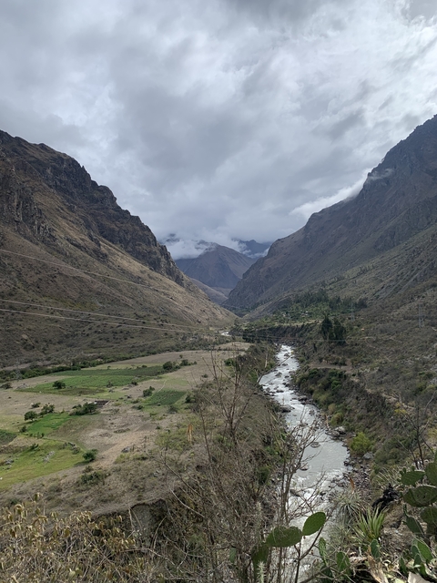       River flowing through a valley flanked by mountains.
  