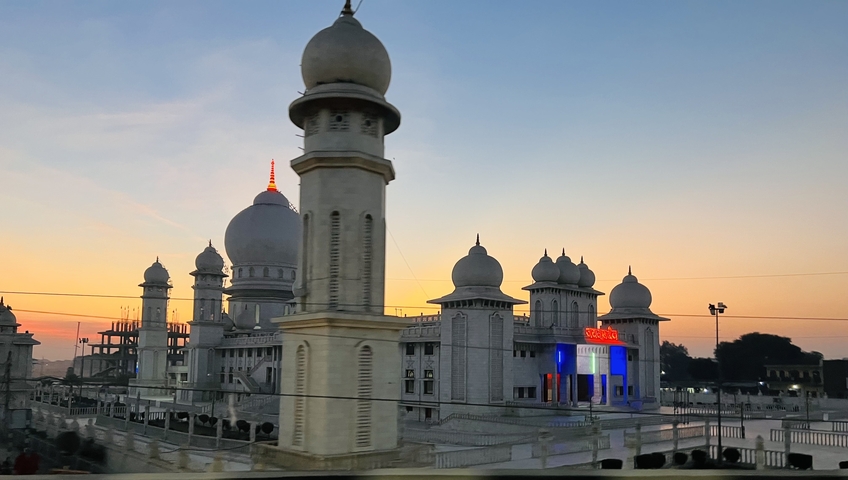 Architectural building with domes at sunset in an urban setting.