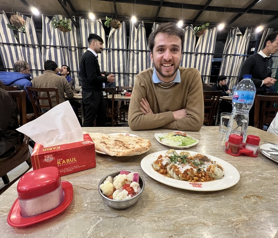       A man sitting at a table with traditional food.
  