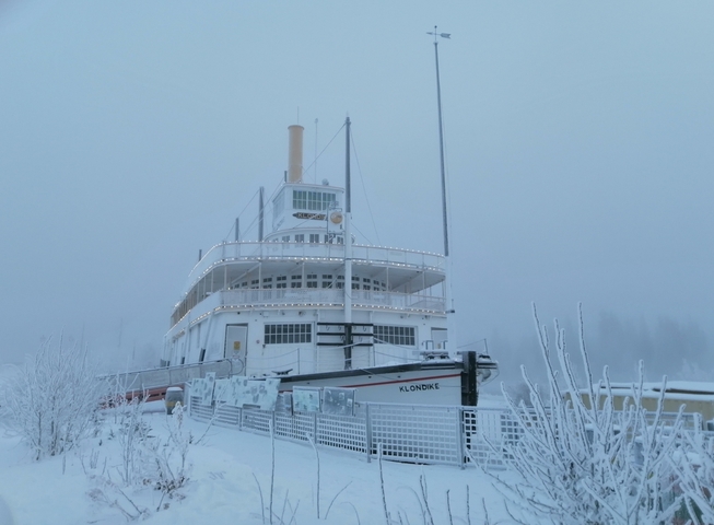       Klondike steamboat in a snowy landscape during foggy conditions.
  