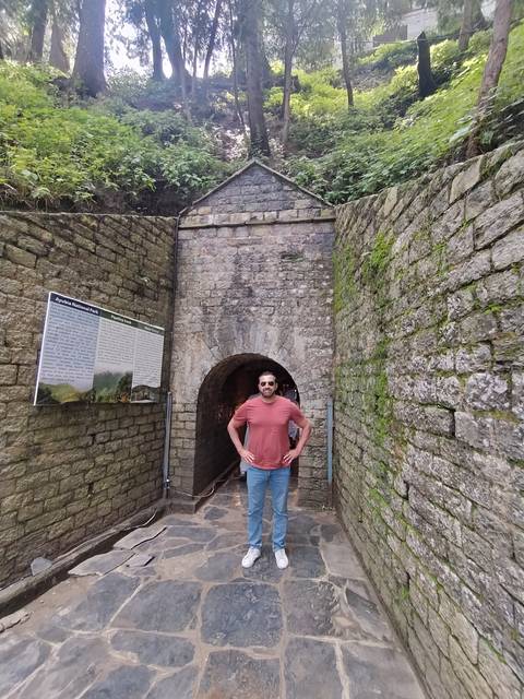 Individual in front of an old stone structure.