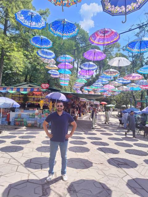       Person in a colorful umbrella installation.
  
