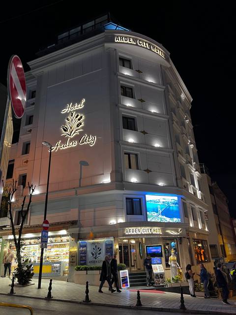 A lit building at night with a prominent hotel sign.