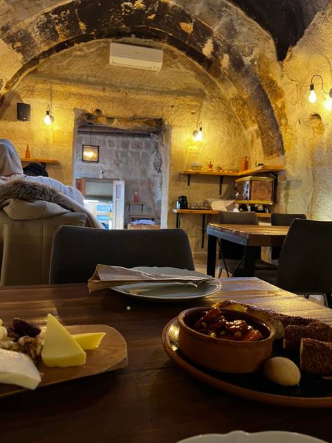       An interior of a cozy restaurant with food on a table.
  