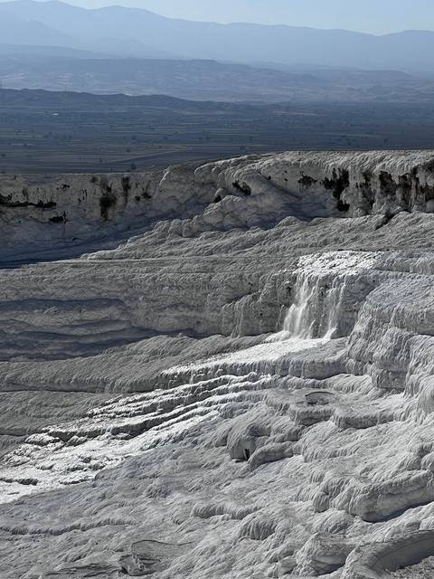 White terraced landscape with a flowing water feature.