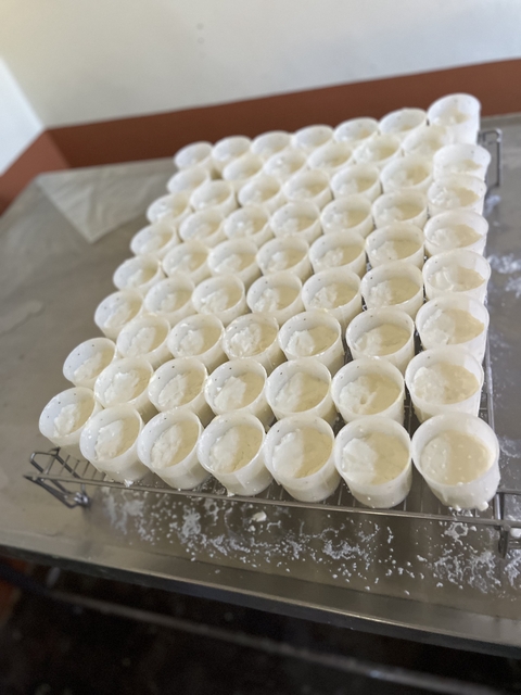       Numerous small white cups filled with a creamy substance.
  