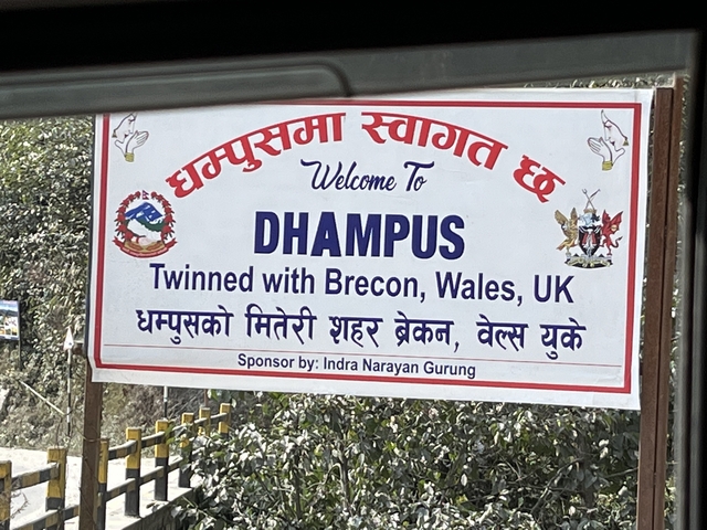 Welcome sign for Dhampus in English and Nepali.