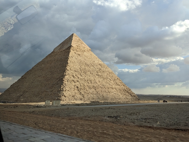 Pyramid with partially cloudy sky in the background.