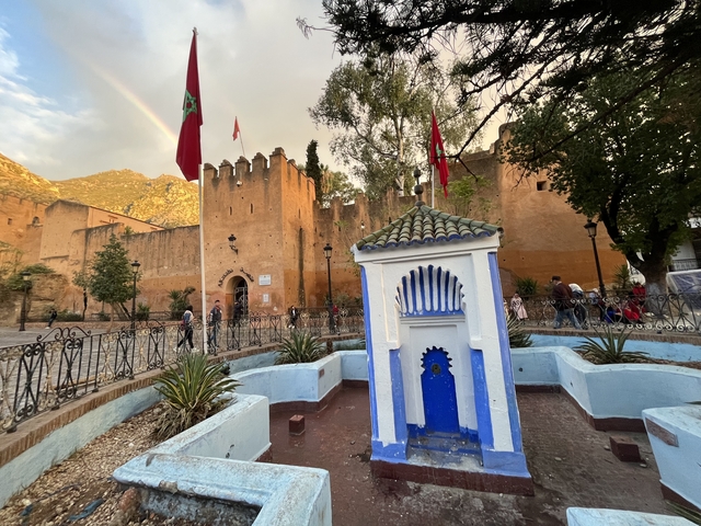       Architectural site with walls and Moroccan flags.
  