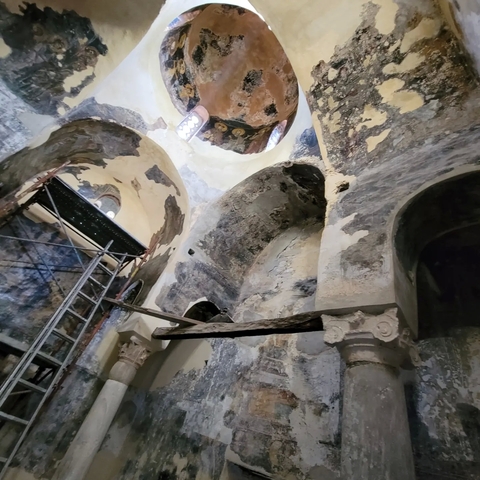       Interior of an ancient, rustic building being restored.
  