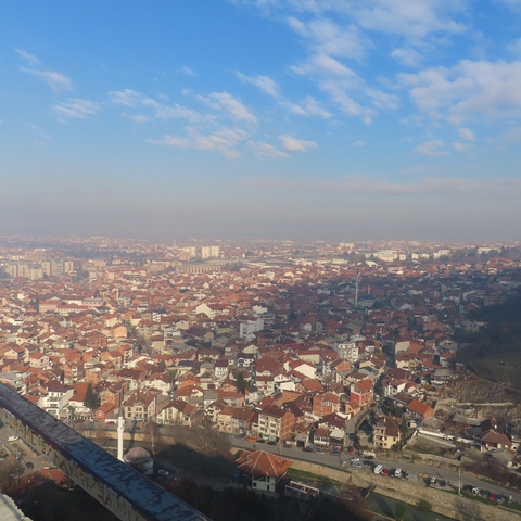       Aerial view of a city with red-tiled roofs.
  