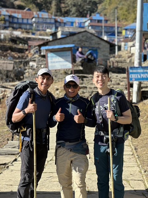 Three hikers posing with trekking poles.