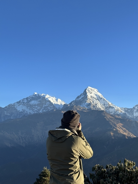 Person admiring snowy mountain peaks.