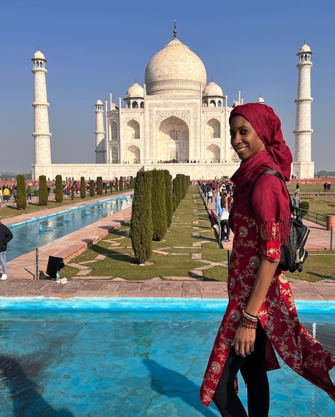 Woman posing in front of the Taj Mahal.