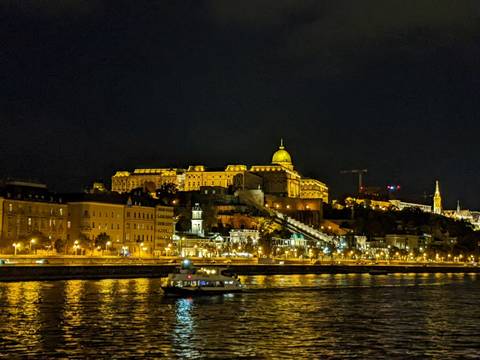       Night view of a lit cityscape with river.
  