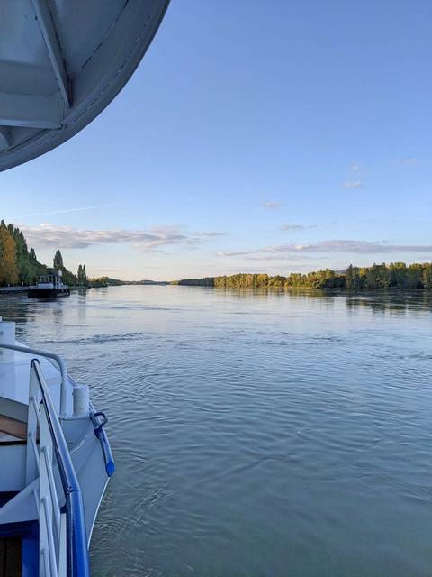       River view with greenery along the banks under a clear blue sky.
  