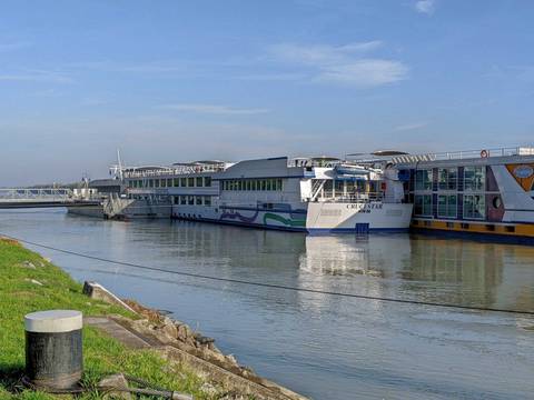 Cruise ship named CRUCESTAR docked on a calm river.