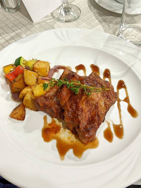 Plate with ribs and roasted potatoes.