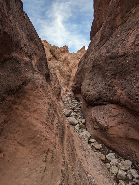       Rocky narrow canyon with a dry riverbed and stone walls.
  