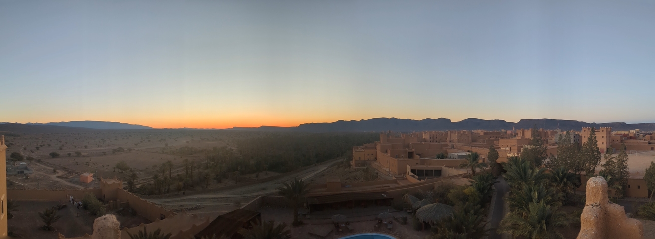       A panoramic view of a desert town at sunset.
  