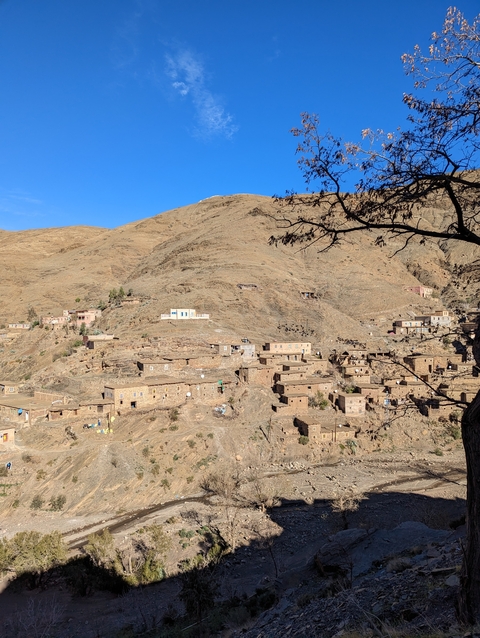       Mountain village with stone houses built on a hillside.
  